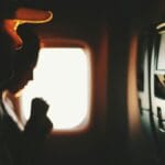 Sylwetki pasażerów przy oknie w trakcie spokojnego lotu samolotem