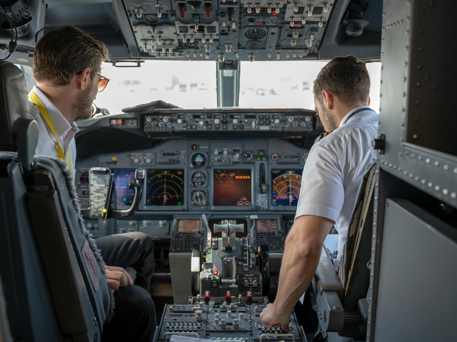 Co pilot robi podczas lotu, gdy pasażerowie widzą tylko spokój Dwóch pilotów w kokpicie samolotu obsługuje nowoczesne przyrządy