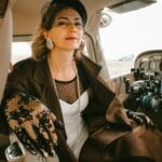 Elegancka pilotka w kokpicie samolotu pewnie patrzy przed siebie