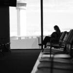 Kobieta w terminalu lotniska na tle wieży kontroli ruchu lotniczego