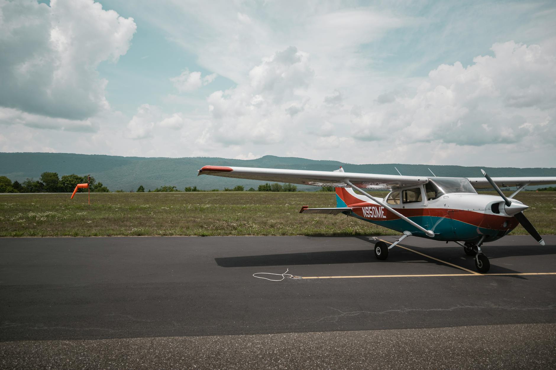 Mały samolot turystyczny zaparkowany na lotnisku z widokiem na góry