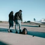 Para pasażerów idzie w stronę prywatnych samolotów w hangarze