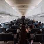 Pasażerowie siedzący w kabinie samolotu pasażerskiego podczas lotu