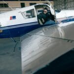 Pilot w kabinie małego samolotu Piper w hangarze przed lotem