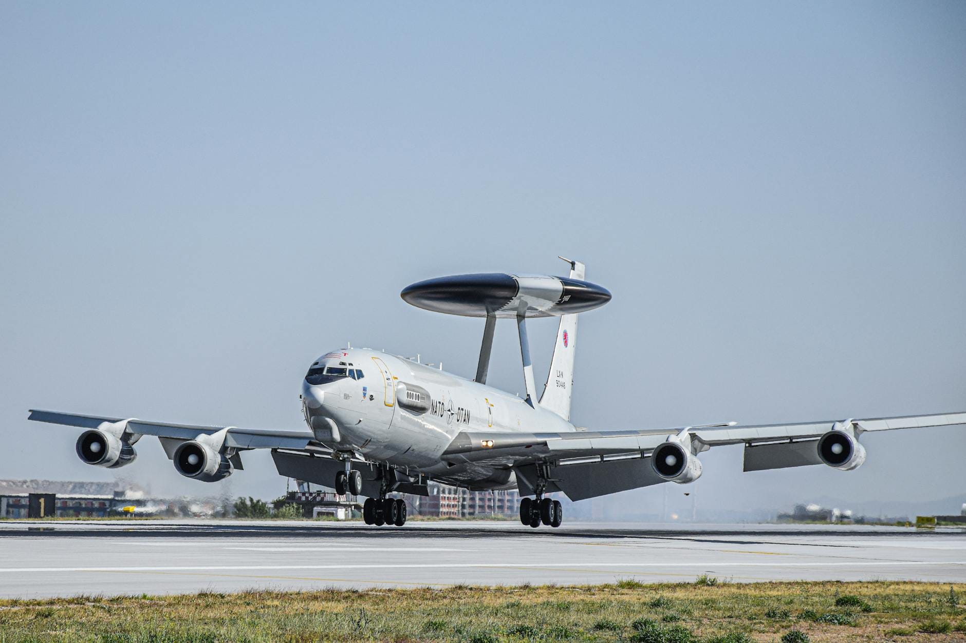 Co potrafi AWACS i dlaczego jest kluczowy dla obrony? Samolot NATO AWACS na oświetlonym słońcem pasie startowym