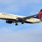 Samolot pasażerski Delta Air Lines leci na tle czystego, błękitnego nieba
