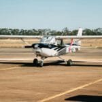 Samolot szkoleniowy PPL zaparkowany na pasie startowym w słoneczny dzień