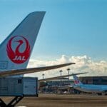 Samoloty Japan Airlines stojące na płycie lotniska w słoneczny dzień