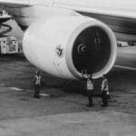 Technicy lotniczy sprawdzają silnik odrzutowca na płycie lotniska