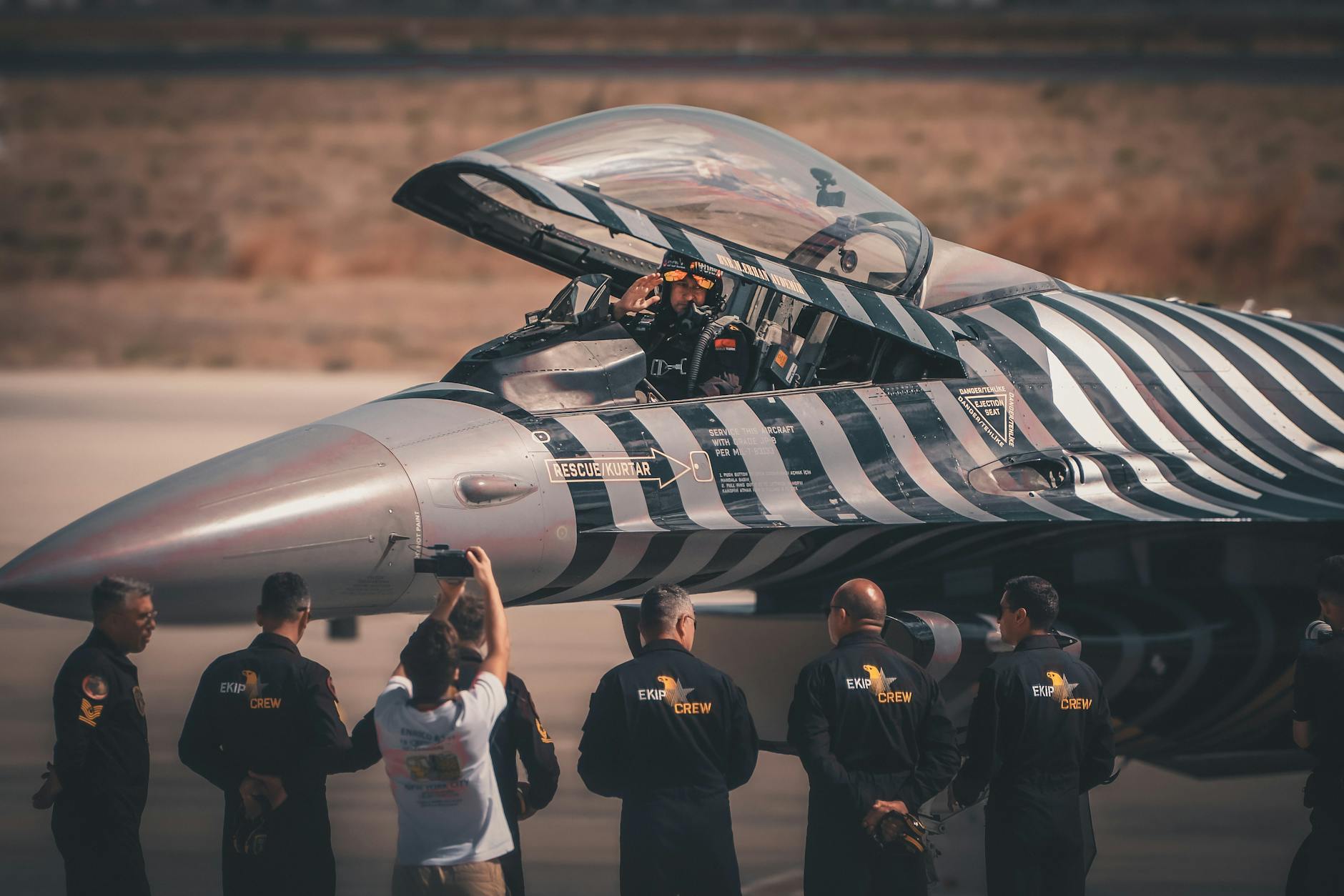 Załoga naziemna przygotowuje wojskowy myśliwiec na płycie lotniska