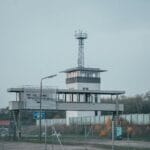Nowoczesna wieża kontroli lotów na lotnisku za ogrodzeniem