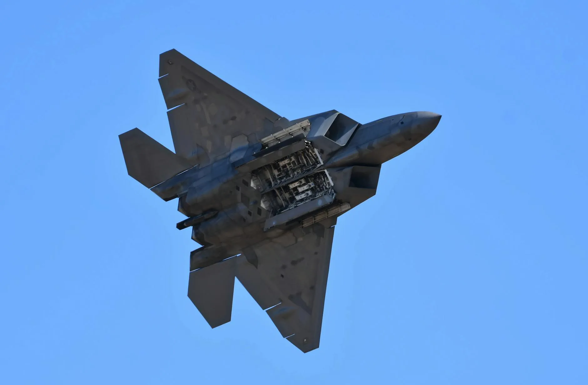 Myśliwiec wojskowy w locie na tle czystego, błękitnego nieba