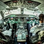 Pilot w kokpicie samolotu aktywnie obsługujący przyrządy pokładowe