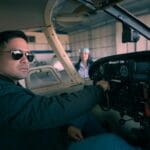 Młody pilot w kokpicie samolotu w hangarze szykuje się do startu