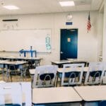 Pusta jasna klasa z ławkami, tablicą i flagą USA